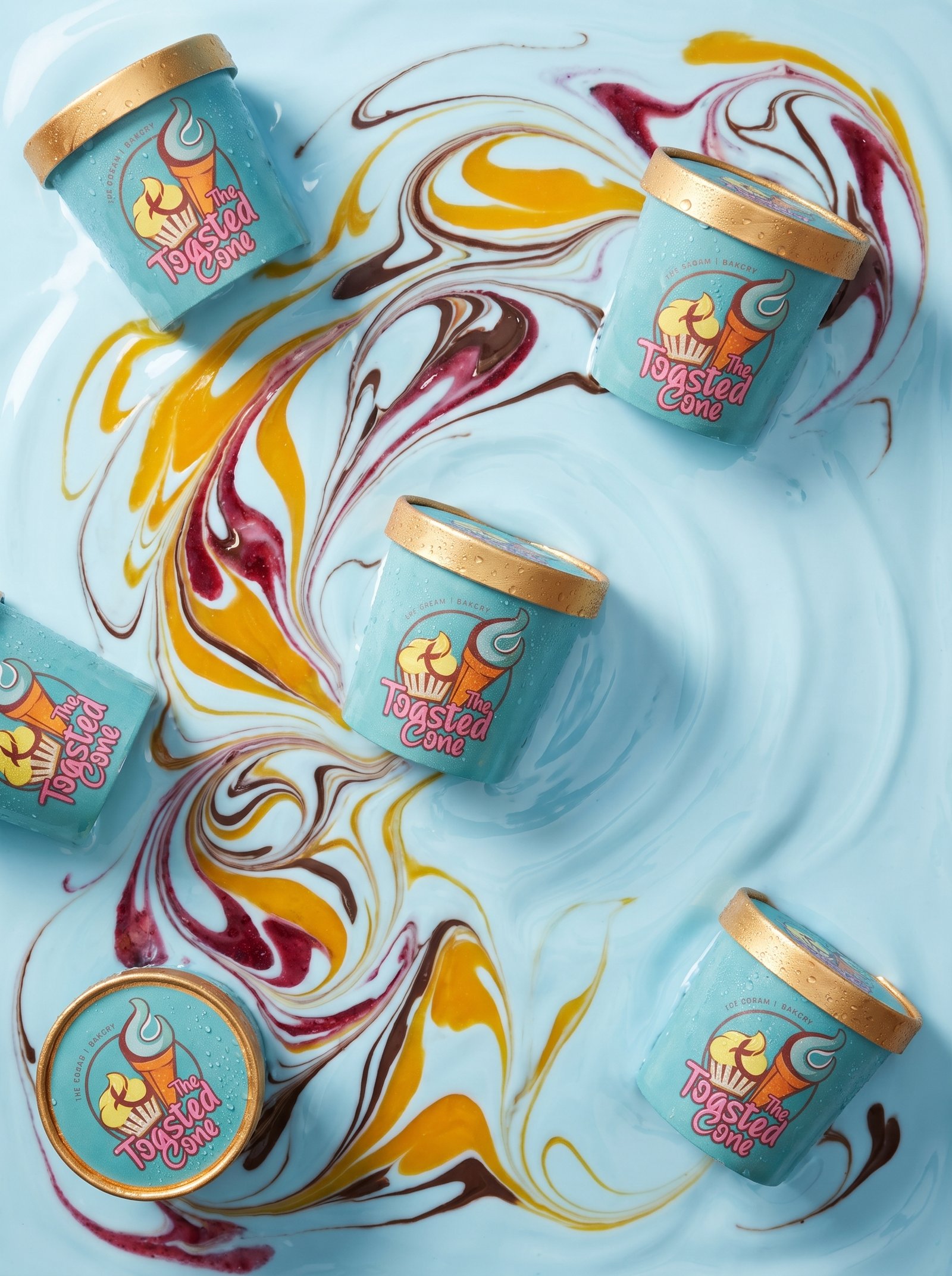 Toasted Cone pint tubs arranged on colorful ice cream swirls